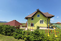 Dvorište apartmana sa klackalicama i letnjikovcem